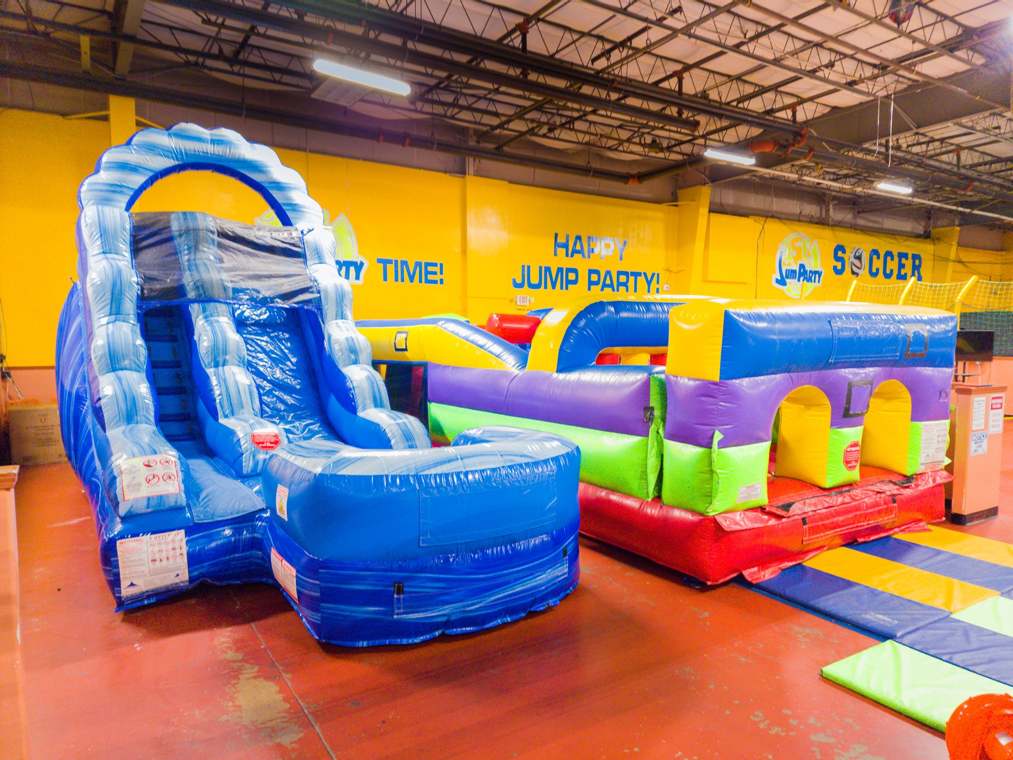 Jump Party USA has two bounce houses for toddlers and small kids. A blue bounce house with a slide and a bounce house obstacle course