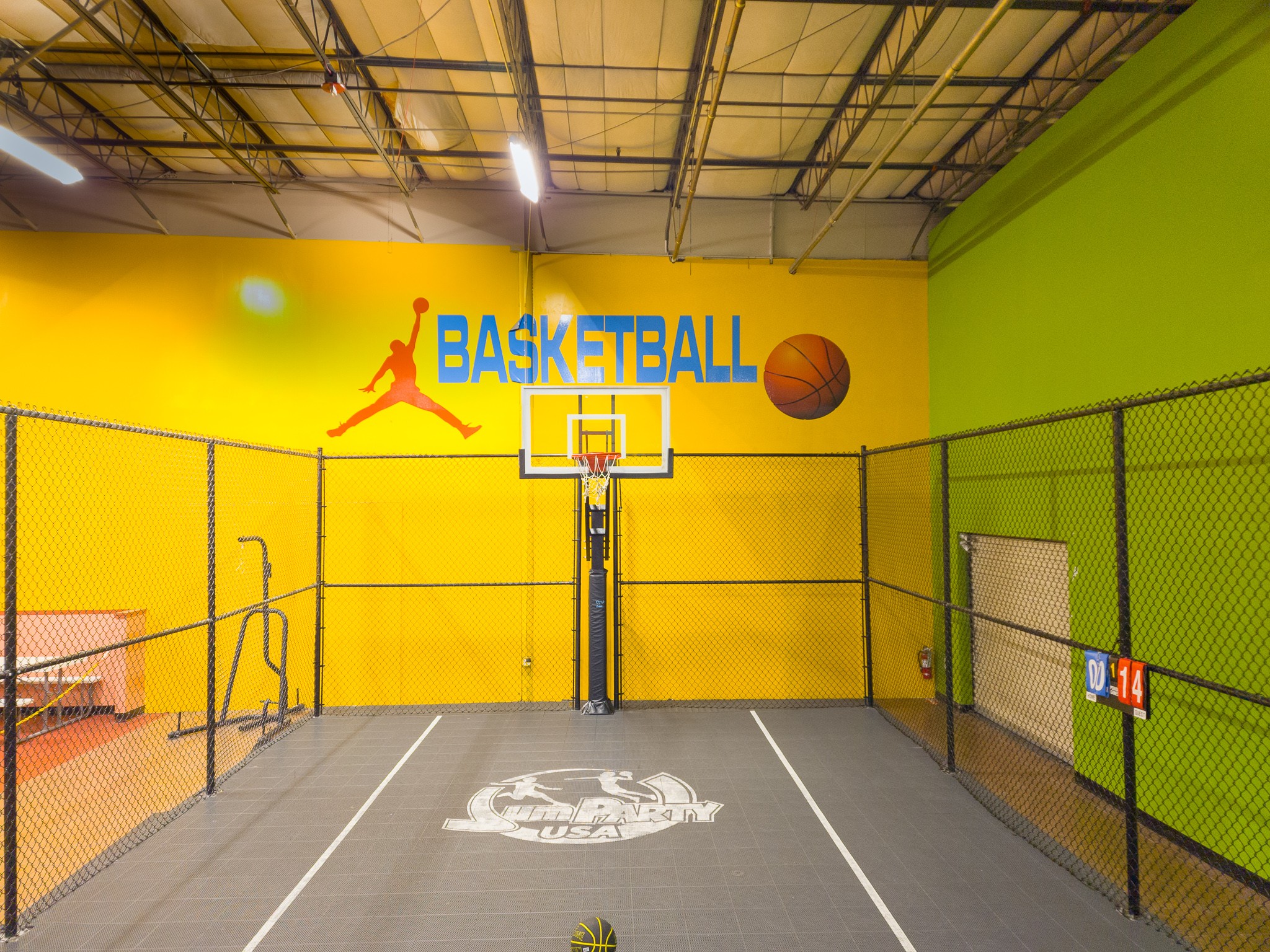 Play basketball with friends at Jump Party USA's Indoor Basketball court with basketball.