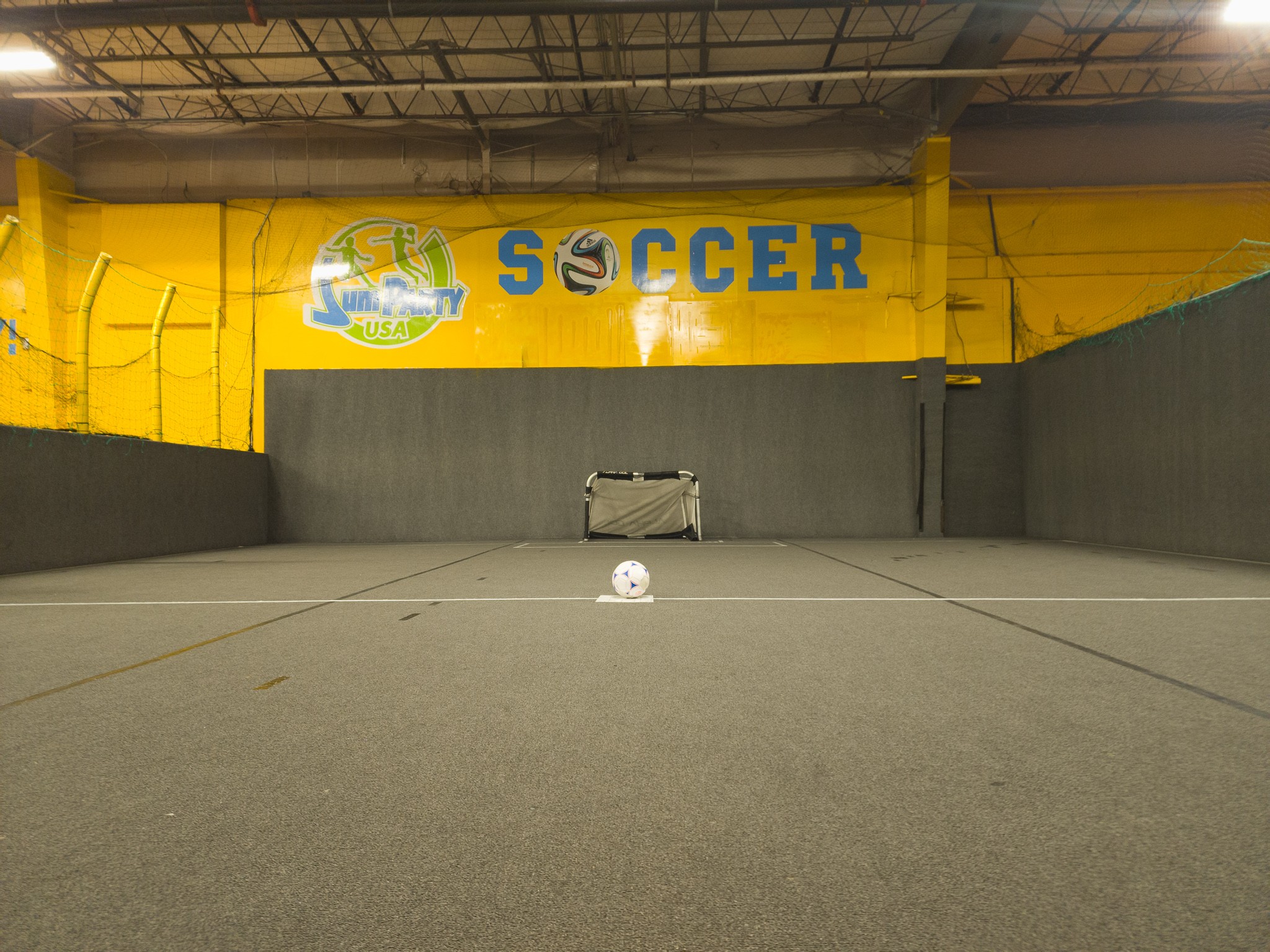 Jump Party USA has an indoor soccer field with soccer balls. Adults and kids can safely play within a netted court